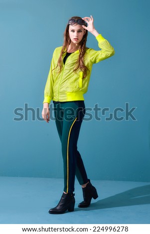 Full length fashion young model walking on blue background