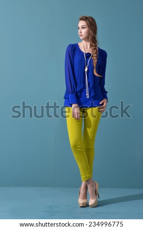 Full length fashion young model standing on blue background