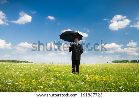 The person with an umbrella in the field