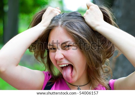 Teen caucasian girl staring into the camera and sticking her tongue out