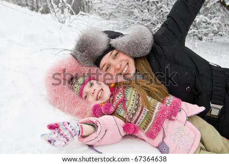 young mother and daughter in winter clothing in a winter woods