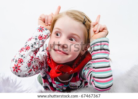 studio shot of pretty little girl with fingers like horns