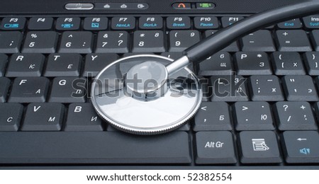 Medical stethoscope laying on a computer keyboard