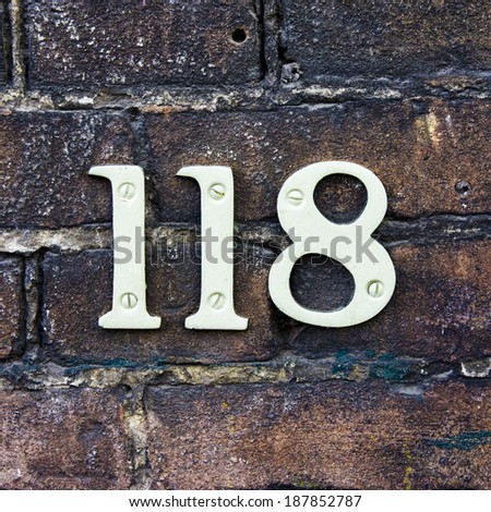 house number one hundred and eighteen on a brick wall