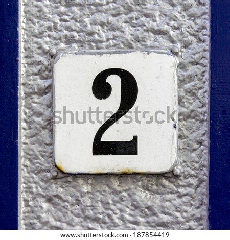 House number two on an enameled plate. Black lettering on a white background
