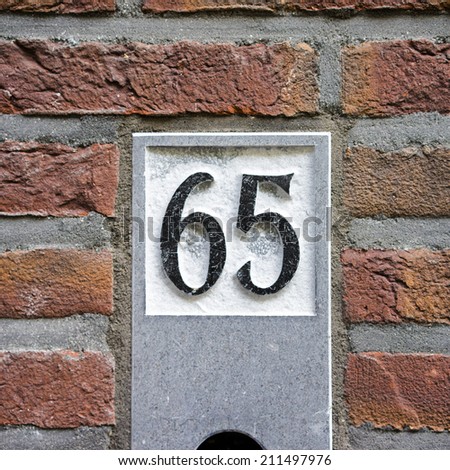 House number sixty five, carved in natural stone.