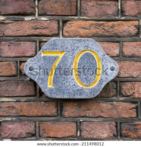Golden house number seventy, engraved in natural stone
