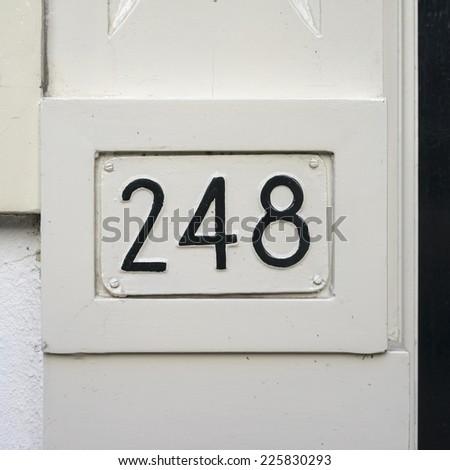 house number two hundred and forty-eight embossed in a metal placard. Painted over in black.