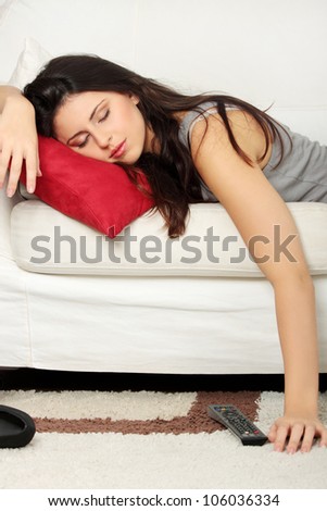 Beautiful woman is sleeping on red pillow. Pretty girl fall asleep on the couch during watching television.