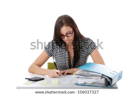 Young woman  in black glasses sitting at the desk with folder and calculator. Long-haired brunette making notes. Isolated on the white background.