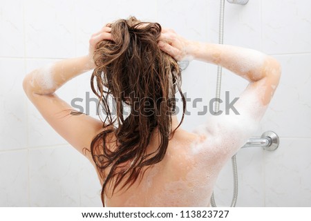 Young fit woman in shower washing her perfect fit body