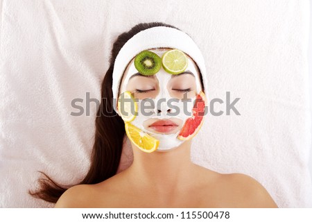 Beautiful young woman with fruit mask on a face