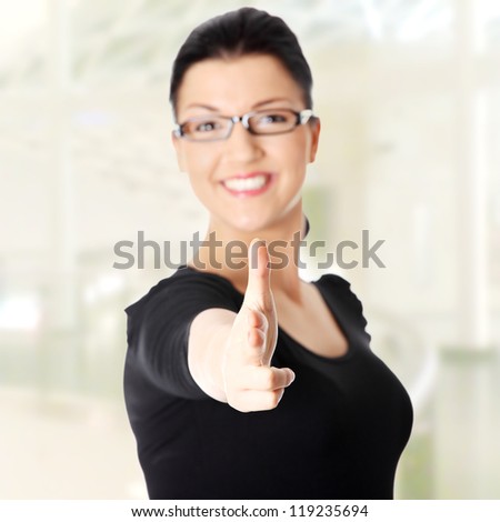 Young beautiful happy caucasian woman pointing on you . Focus on hand