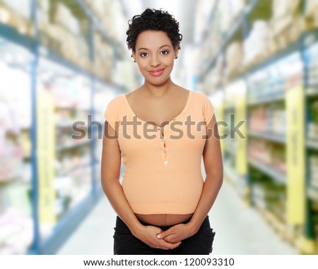 Front view portrait of a beautiful young pregnant woman in store