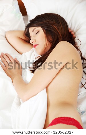 Closeup portrait of a cute young woman sleeping on bed