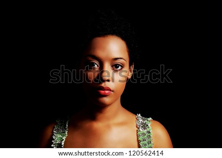 Portrait of beautiful serious afro american woman over black background