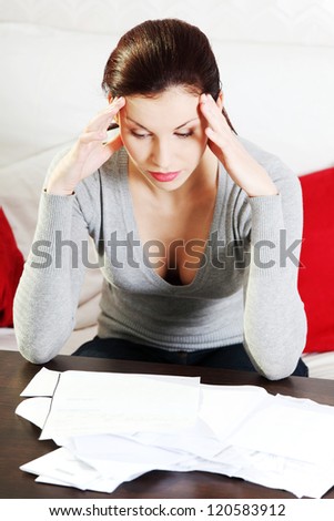 Young beautiful woman stressed because of bills.