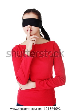 Blindfold woman with finger on lips. Gesturing for quiet and keeping secret