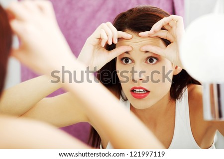 Mirror Reflection Of A Woman Worrying Because Of Wrinkles On Her Forehead.