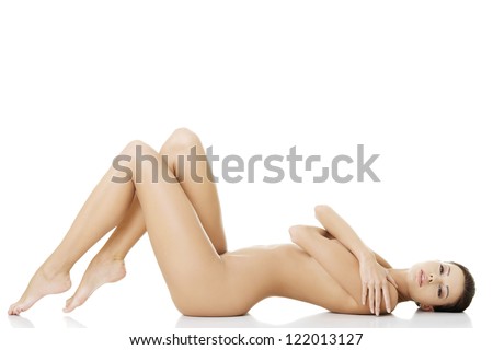 Sexy fit naked woman with healthy clean skin lying down, isolated on white