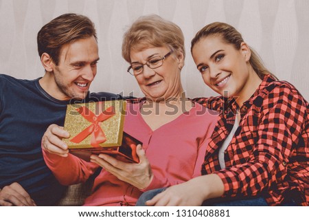 Grandchildren are giving a present to her grandmother. Family connections.