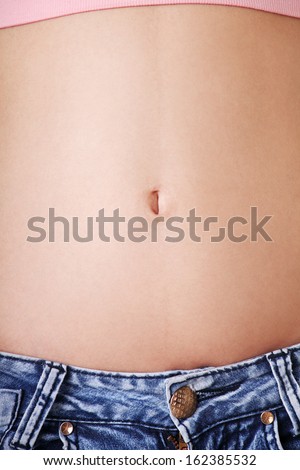 Slim fit female\'s belly. Closeup. Isolated on white.