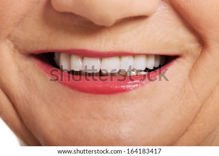 Close up on ol woman\'s perfect smile, teeth. Over white.