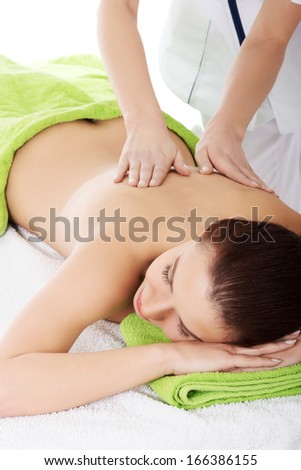 Beautiful woman lying on bed in spa salon having massage. Spa concept.