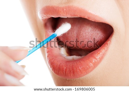 Young woman putting ear stick into mouth. Close up.