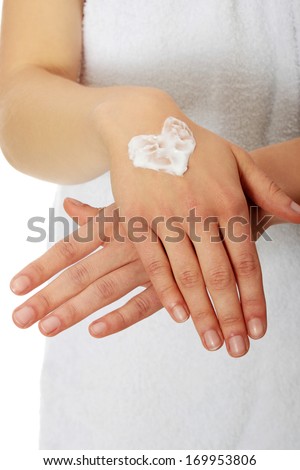 Woman with heart shape cream on hand. Over white.