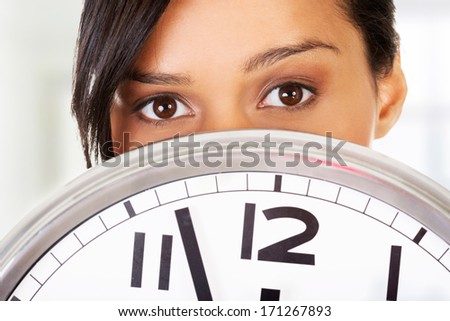 Portrait of shocked woman with clock