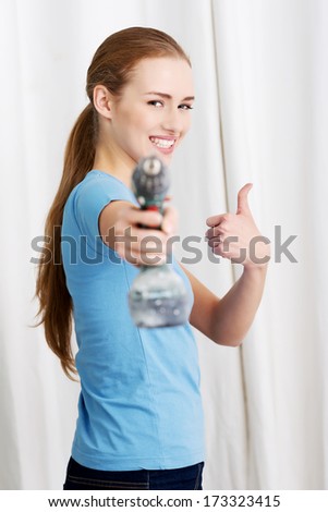 Casual beautiful house wife holding drill. Indoor background.