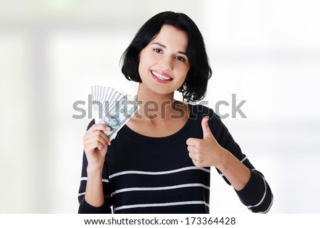 Young woman with dollars gesturing thumbs up.