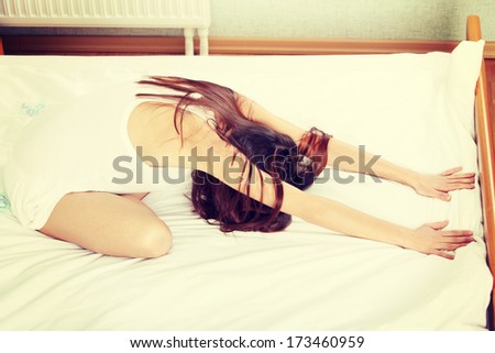 Beautiful brunette woman on bed practicing yoga
