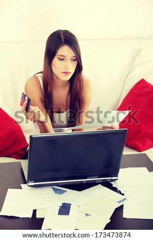 Young woman\'s paying bills. In home.