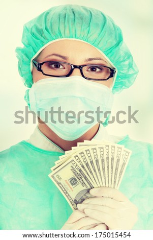 Female surgeon doctor holding money.