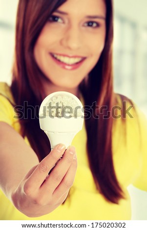 Happy young woman holding led bulb