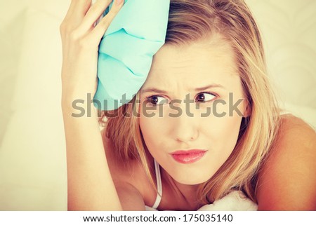 Sick woman in bed with headache