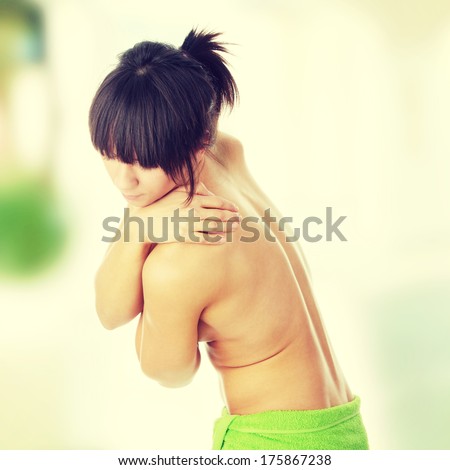 Nude woman from behind. Back pain concept.