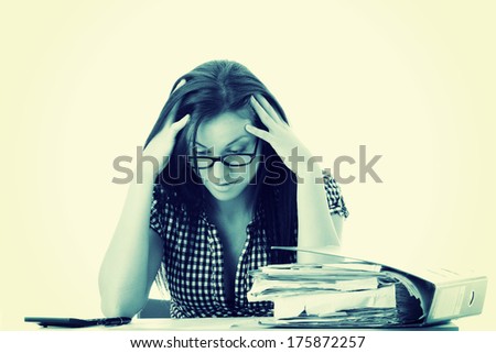 Tired female executive filling out tax forms while sitting at her desk.