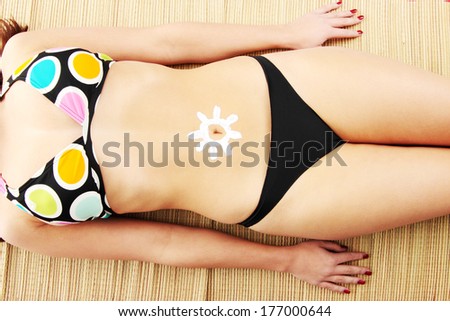 Young woman with sun-shaped sun cream isolated on white background