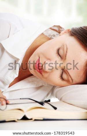 Mature woman sleep on a book