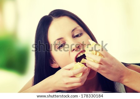Young beautiful woman eating chips
