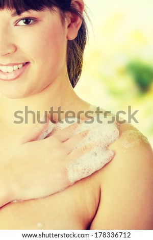 Young woman in shower washing her body