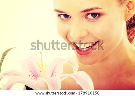 Portrait of the attractive girl without a make-up, with lily flower in hand, isolated on white background