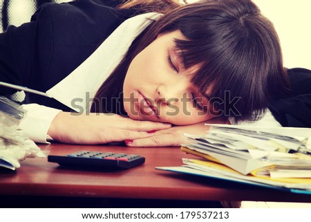 Sleeping female filling out tax forms while sitting at her desk.