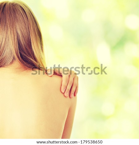 Woman from behind, naked body, pain concept,against abstract green background
