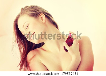 Sensual blond woman applying perfume on her body