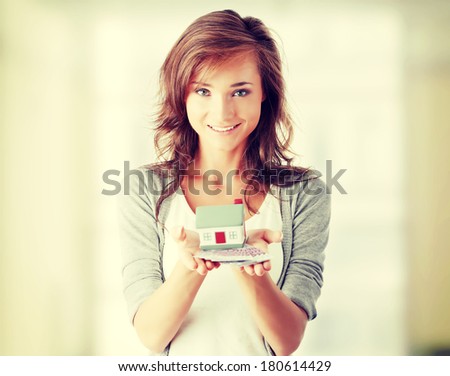 Beautiful young woman holding euros bills and house model over white - real estate loan concept