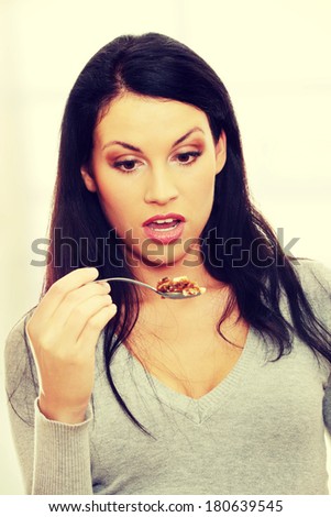 Young beautiful caucasian woman shocked while eating a cake -spoon bending - too much callories concept